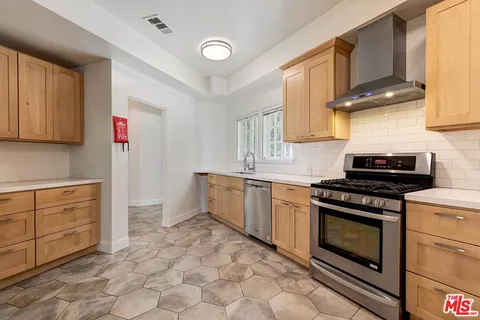 a kitchen with granite countertop a stove top oven sink and cabinets