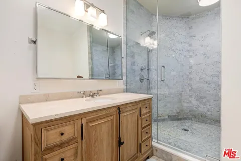 a bathroom with a sink a mirror and a shower