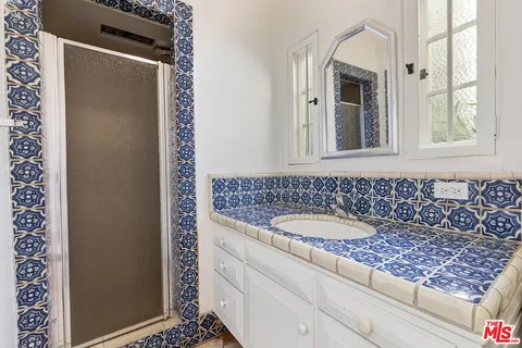 a bathroom with a granite countertop sink and a mirror