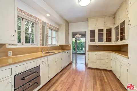 a large white kitchen with cabinets