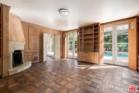 a view of an empty room with a fireplace and a window