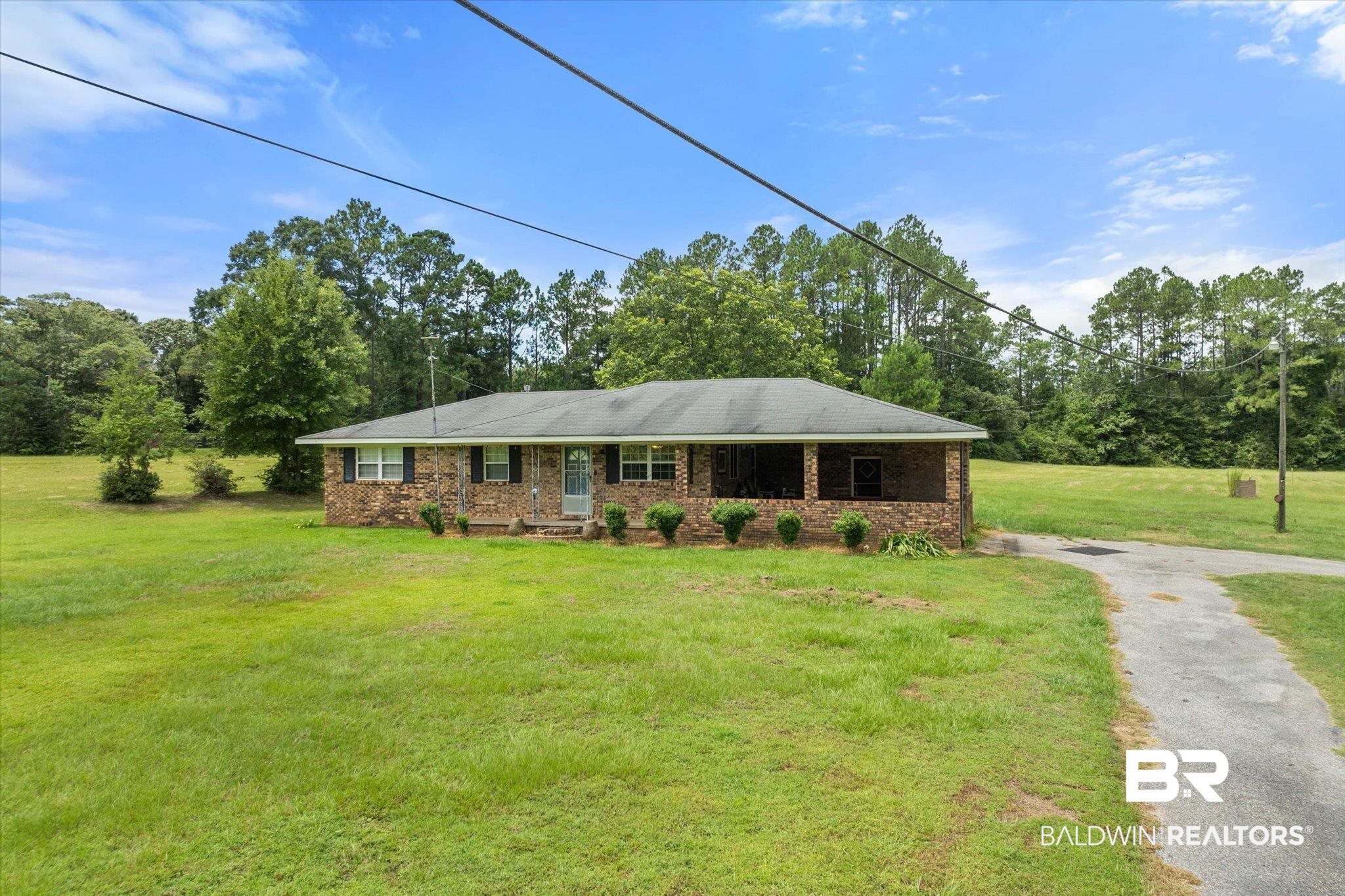 11601 Lott Road Chunchula, AL 36521 - Photo 17 of 34 Ranch-style house featuring driveway, brick siding, and a front yard
