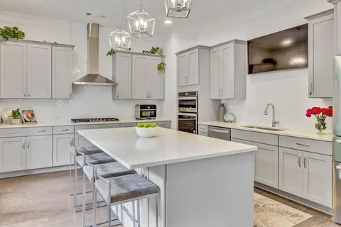 a kitchen with a white cabinets and chairs