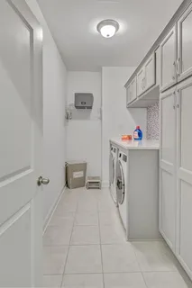 a utility room with cabinets washer and dryer