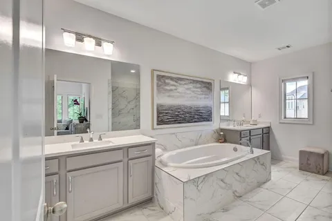 a bathroom with a tub sink and mirror
