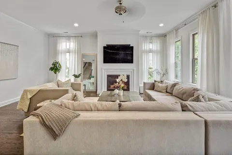 a living room with furniture a flat screen tv and a large window