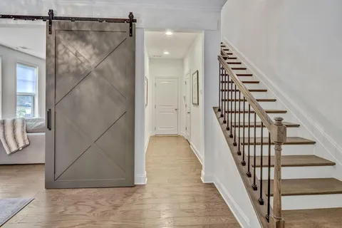a view of a hallway with wooden floor and staircase