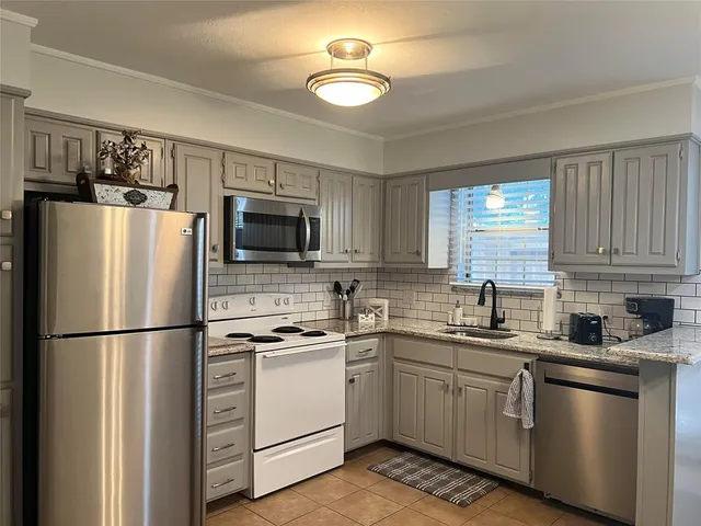 a kitchen with cabinets stainless steel appliances and wooden floor