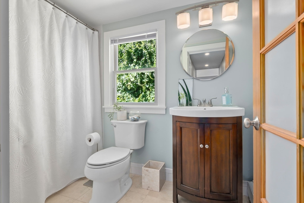 11 Beacon Street Amesbury, MA 01913 - Photo 16 of 42 a bathroom with a sink a mirror a toilet and a window