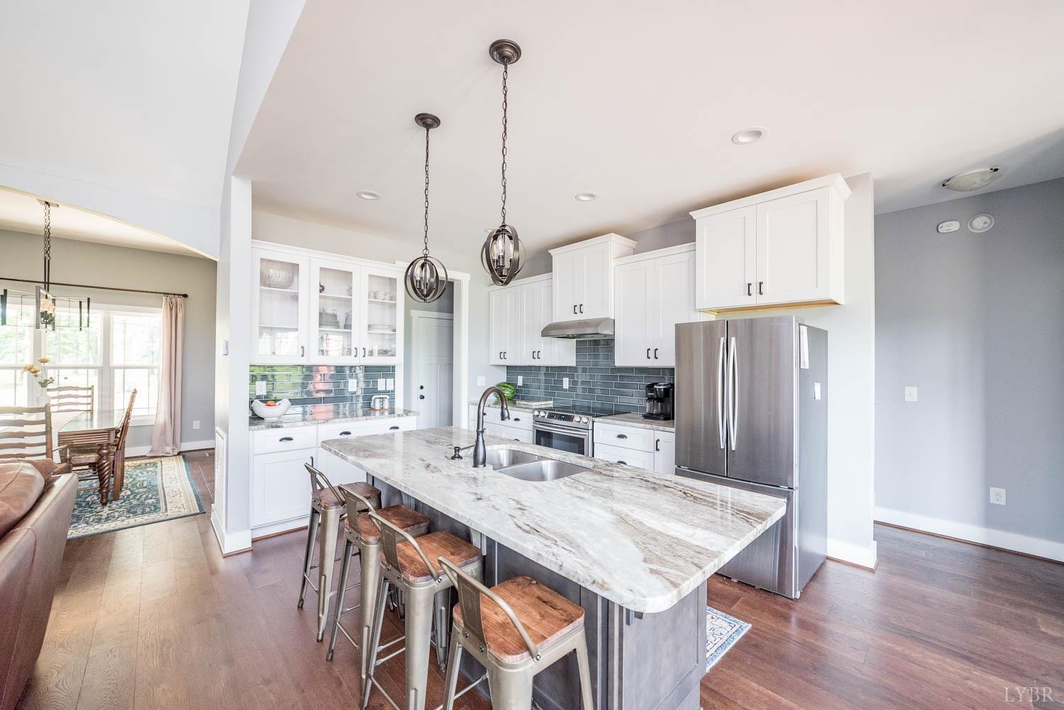 5972 Promise Land Road Appomattox, VA 24522 - Photo 18 of 84 a kitchen with stainless steel appliances granite countertop a stove a refrigerator a kitchen island a dining table and chairs with wooden floor