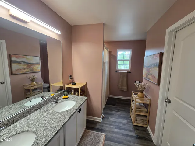 a en suite bathroom with a granite countertop sink and a mirror