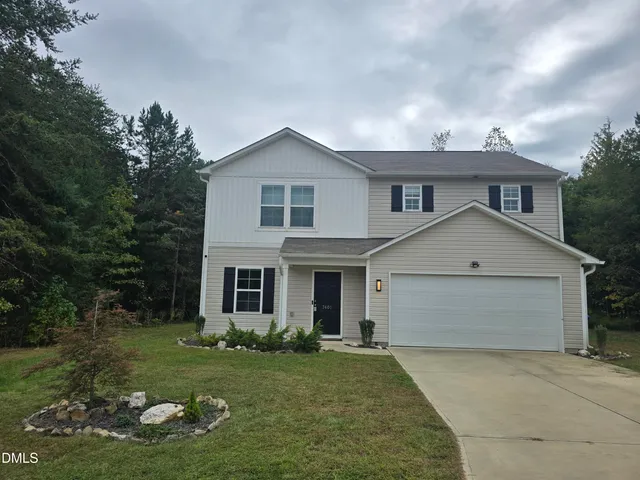 a front view of a house with a yard and garage