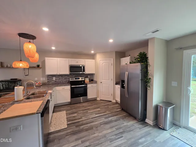 a kitchen with a refrigerator and a stove top oven