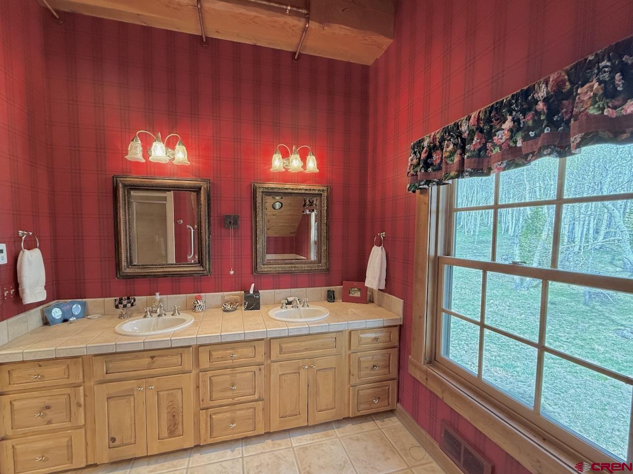 88 Castle Rock Court Crested Butte, CO 81224 - Photo 25 of 44 a bathroom with a double vanity sink and a mirror