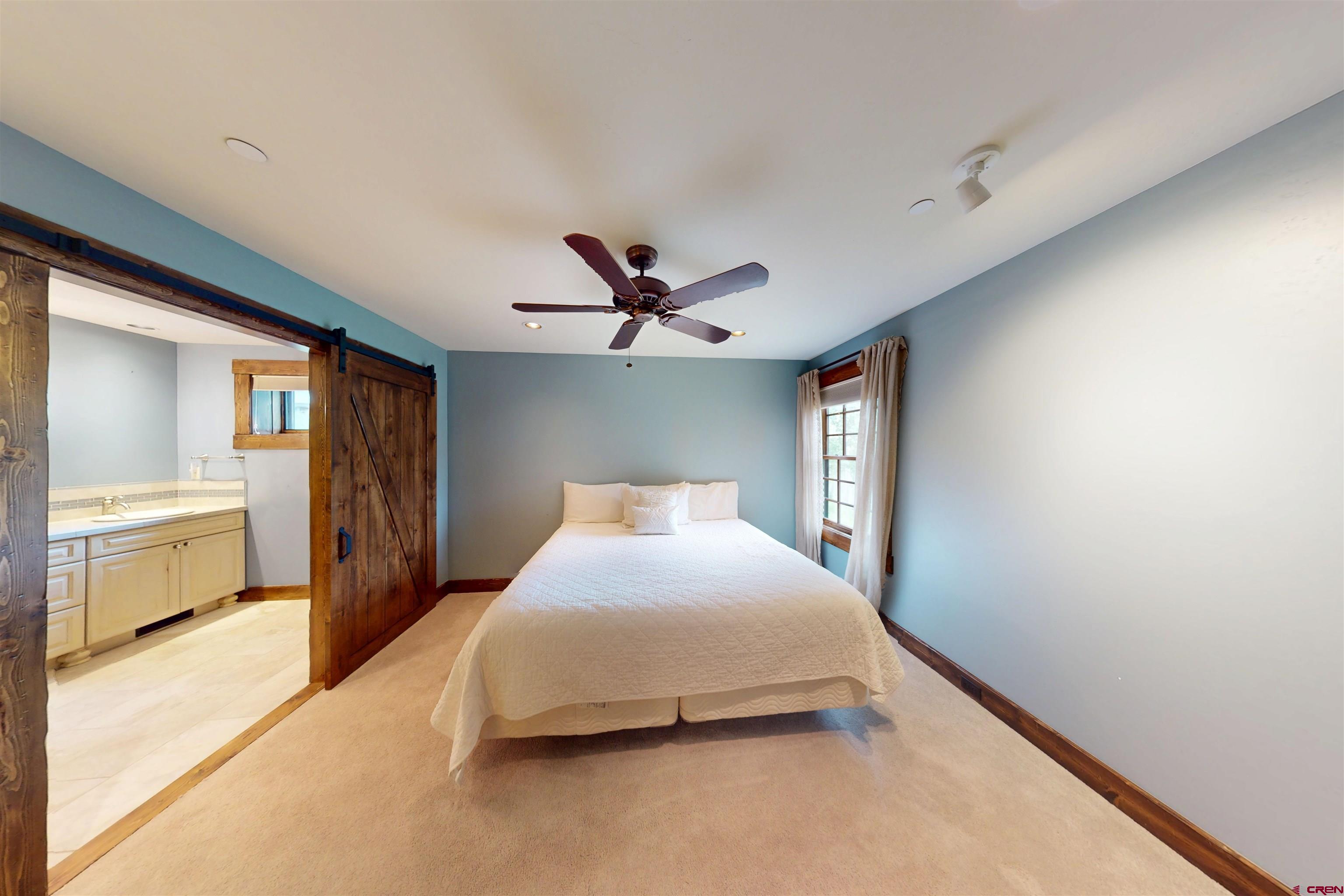 88 Castle Rock Court Crested Butte, CO 81224 - Photo 31 of 44 a bedroom with a large bed and a chandelier