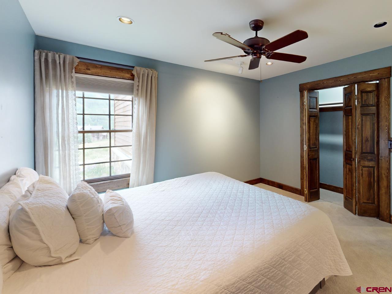 88 Castle Rock Court Crested Butte, CO 81224 - Photo 32 of 44 a bedroom with a large bed and a large window