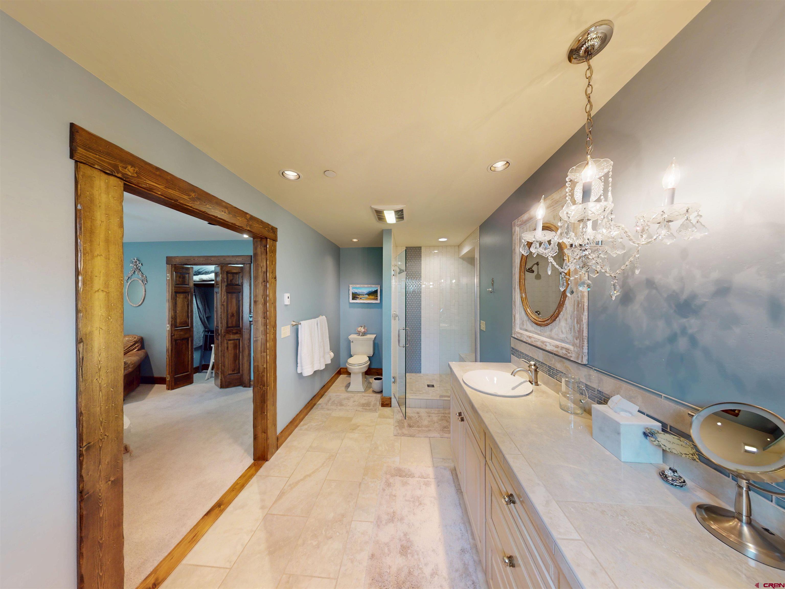 88 Castle Rock Court Crested Butte, CO 81224 - Photo 35 of 44 a spacious bathroom with a double vanity sink a mirror and a shower