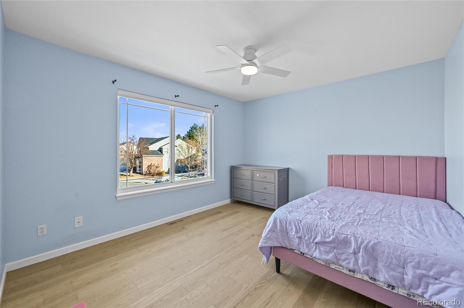 10096 Hughes Place Highlands Ranch, CO 80126 - Photo 30 of 50 a bedroom with a large bed and a chandelier