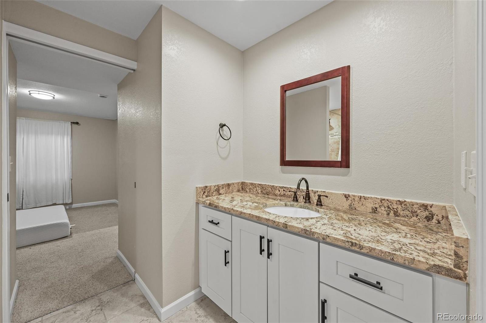 10096 Hughes Place Highlands Ranch, CO 80126 - Photo 40 of 50 a bathroom with a granite countertop sink and a mirror