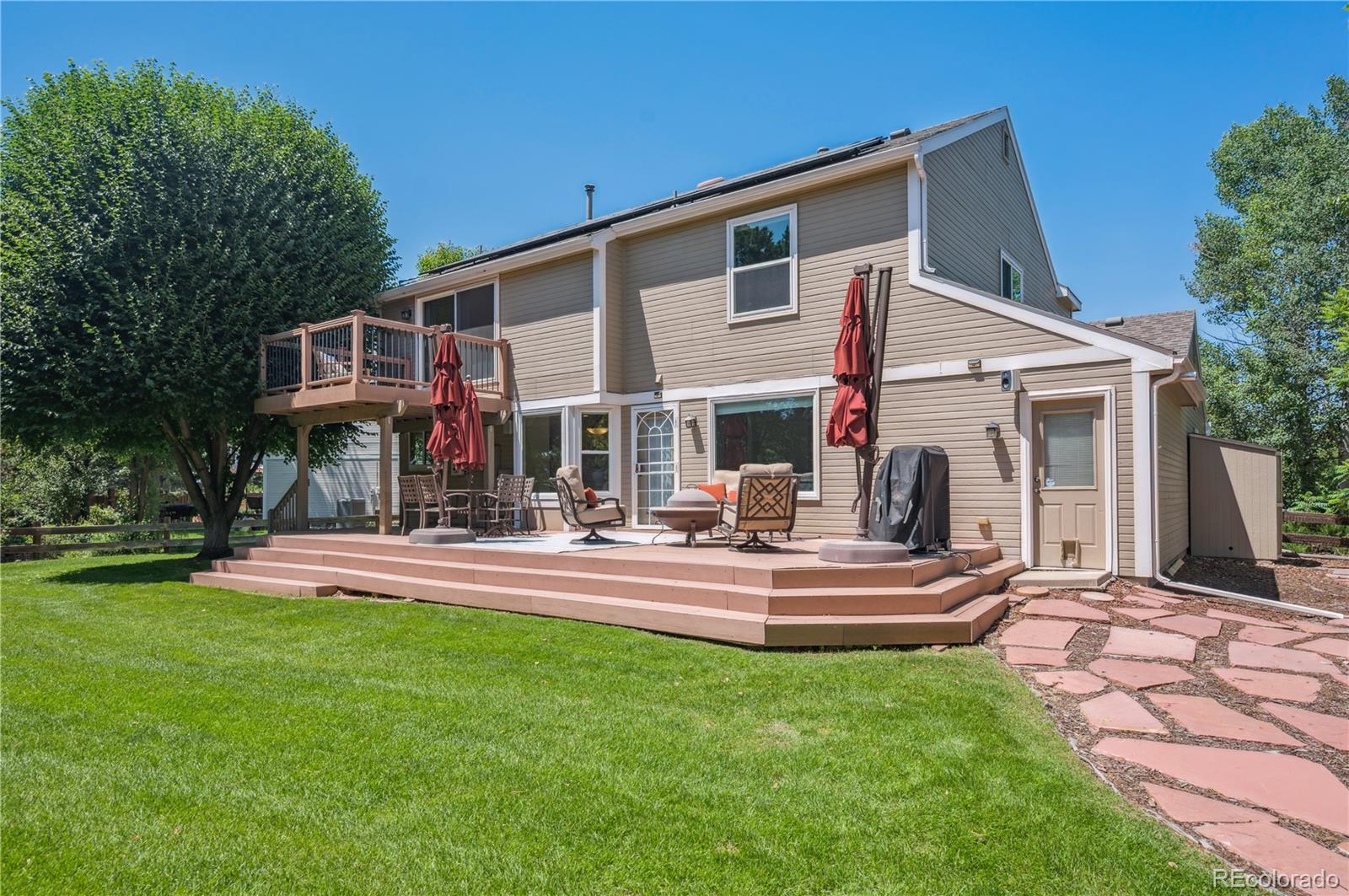 10096 Hughes Place Highlands Ranch, CO 80126 - Photo 46 of 50 a front view of a house with a yard table and chairs