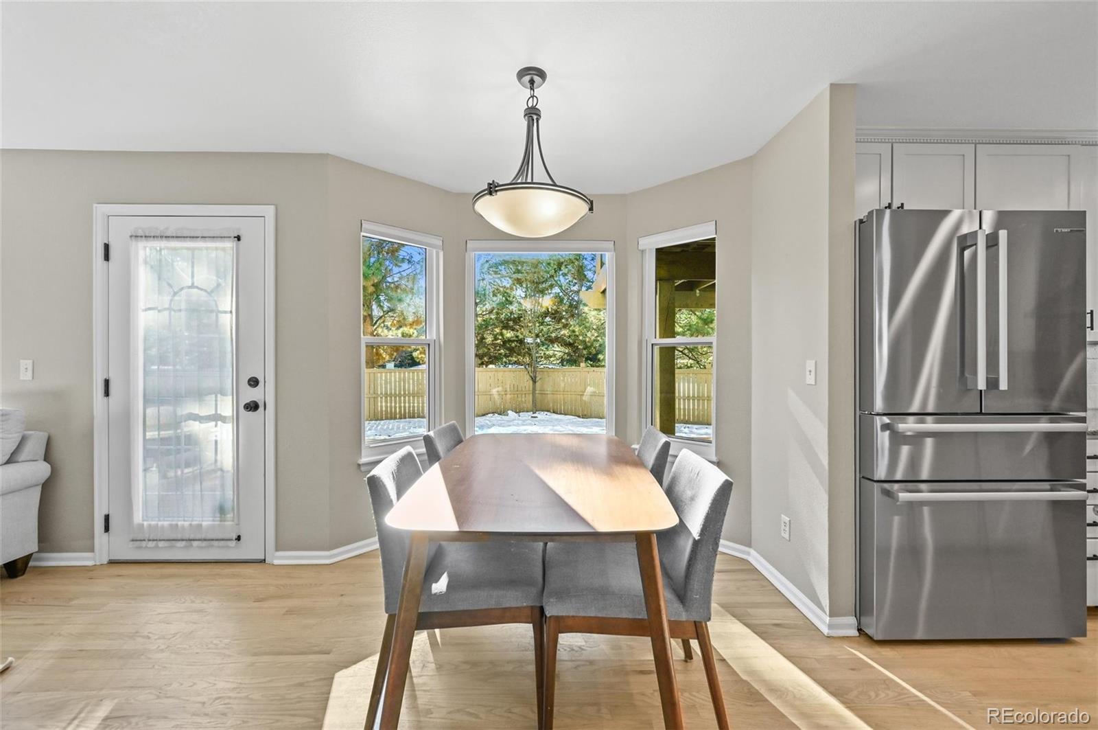 10096 Hughes Place Highlands Ranch, CO 80126 - Photo 10 of 50 a view of a dining room with furniture window and wooden floor