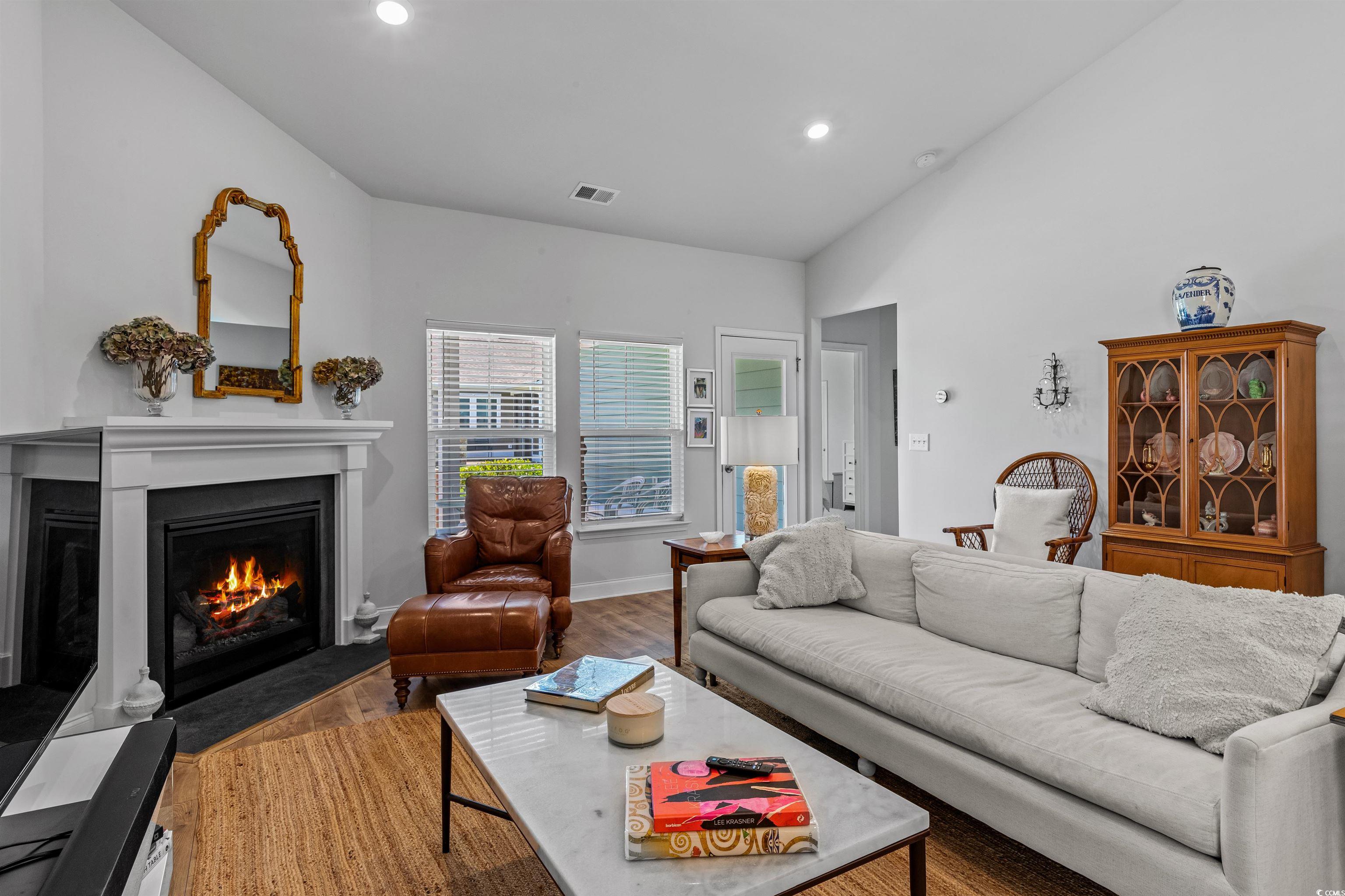2464 Rock Dove Road Myrtle Beach, SC 29577 - Photo 14 of 34 Living area featuring visible vents, a fireplace with flush hearth, wood finished floors, lofted ceiling, and recessed lighting