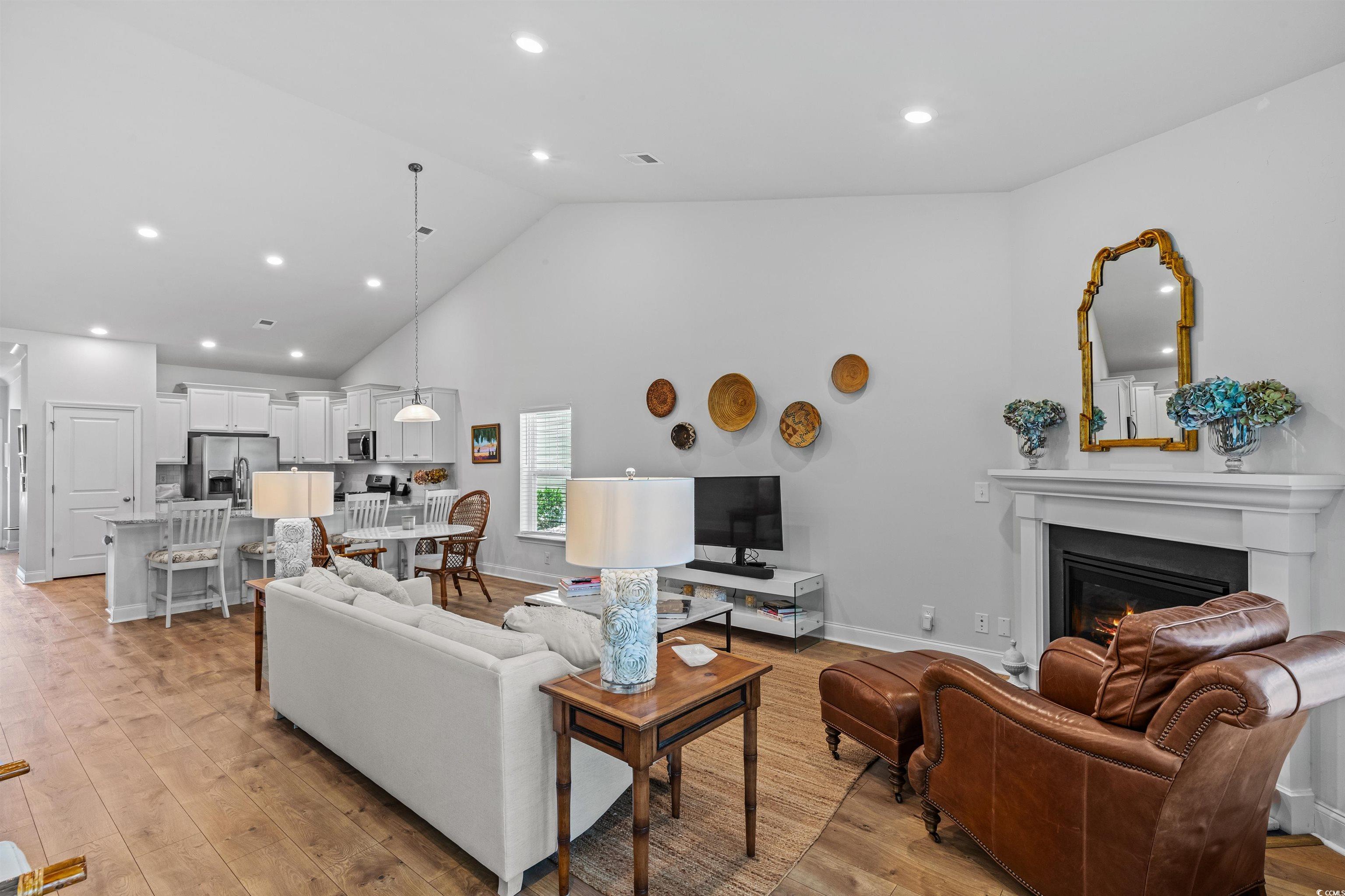 2464 Rock Dove Road Myrtle Beach, SC 29577 - Photo 15 of 34 Living room with a glass covered fireplace, baseboards, high vaulted ceiling, light wood-type flooring, and recessed lighting