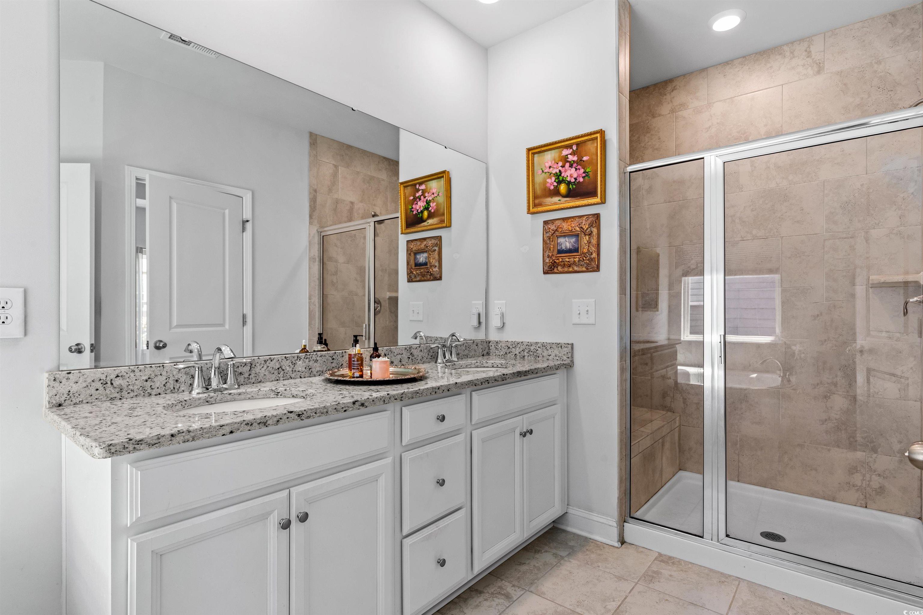 2464 Rock Dove Road Myrtle Beach, SC 29577 - Photo 19 of 34 Bathroom with double vanity, baseboards, a shower stall, and a sink