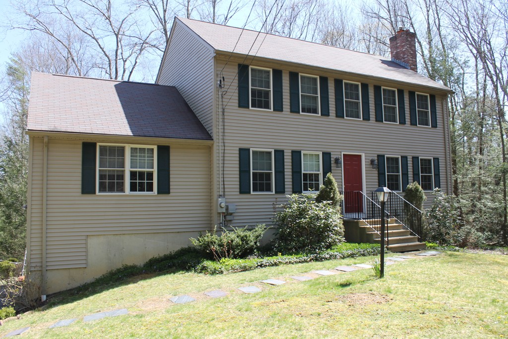 a brick house with a yard and potted plants