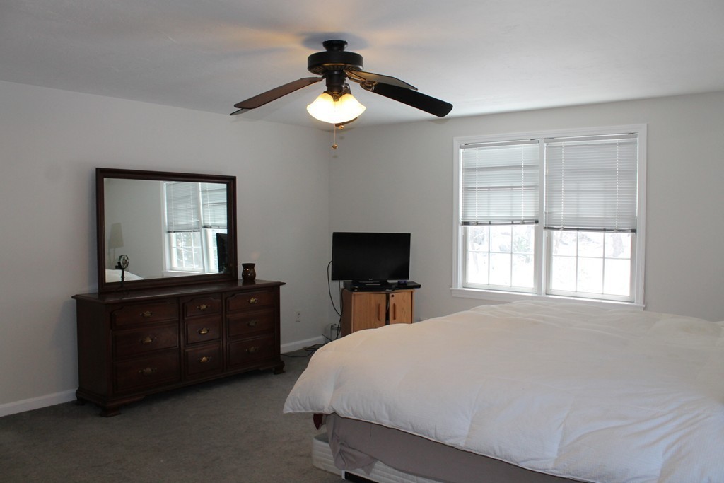 124 Mashapaug Road Sturbridge, MA 01566 - Photo 15 of 30 a bedroom with a bed and a flat tv screen on dresser