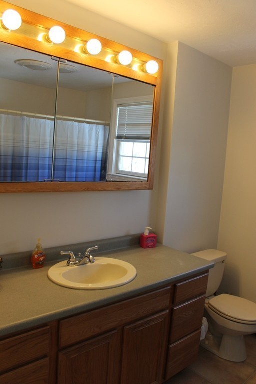 124 Mashapaug Road Sturbridge, MA 01566 - Photo 19 of 30 a bathroom with a sink a mirror and a toilet