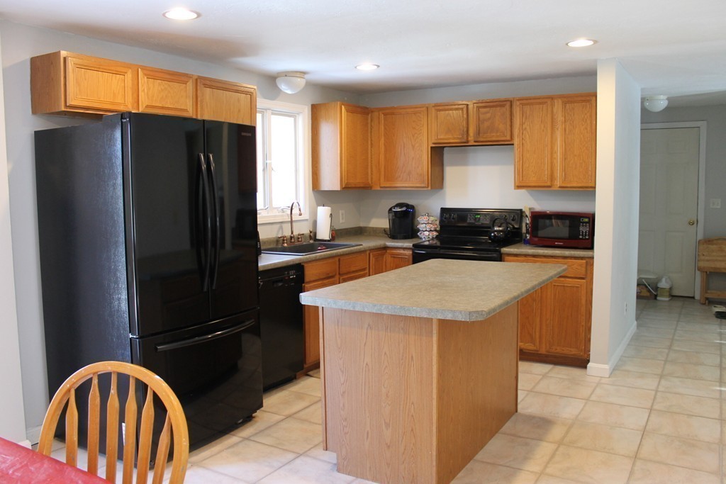 124 Mashapaug Road Sturbridge, MA 01566 - Photo 5 of 30 a kitchen with stainless steel appliances granite countertop a refrigerator a sink a stove a counter space and cabinets