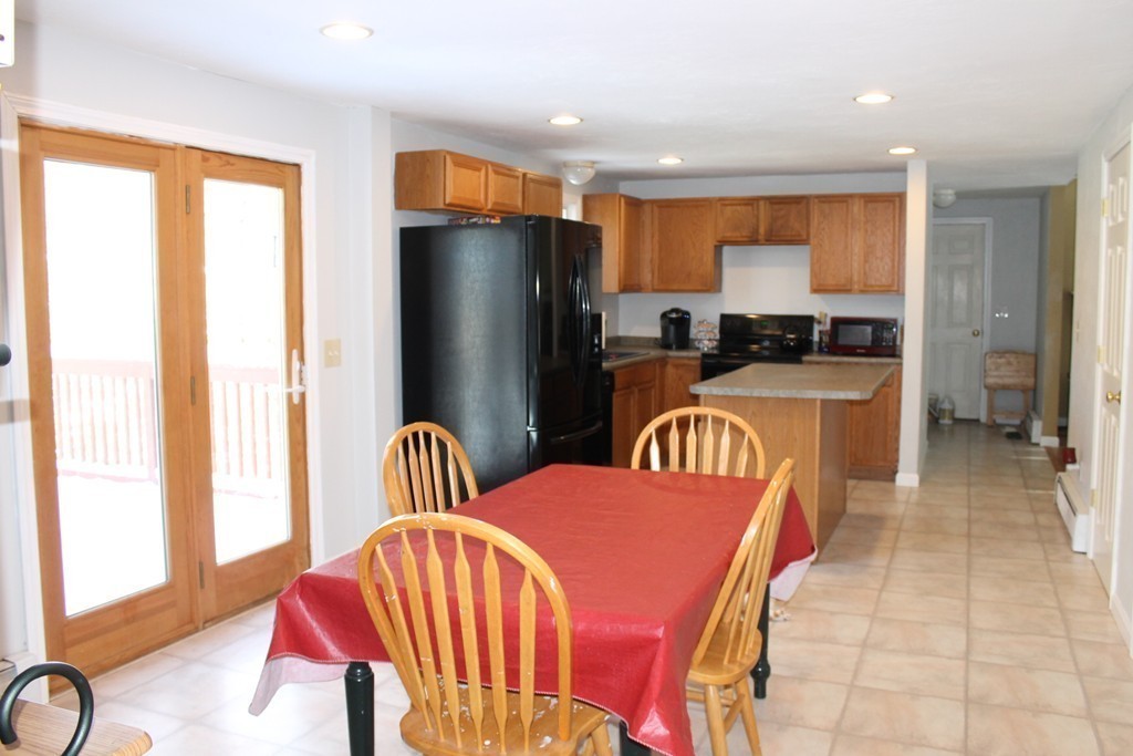 124 Mashapaug Road Sturbridge, MA 01566 - Photo 6 of 30 a kitchen with stainless steel appliances kitchen island granite countertop a refrigerator a stove a sink dishwasher with a dining table and chairs
