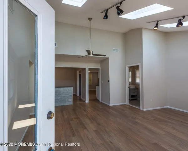 an empty room with wooden floor and windows