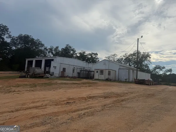 a front view of house with yard and trees in the background