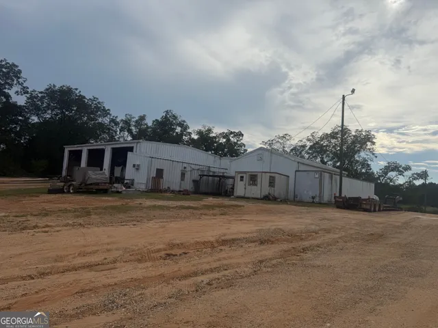 a front view of house with yard and trees in the background