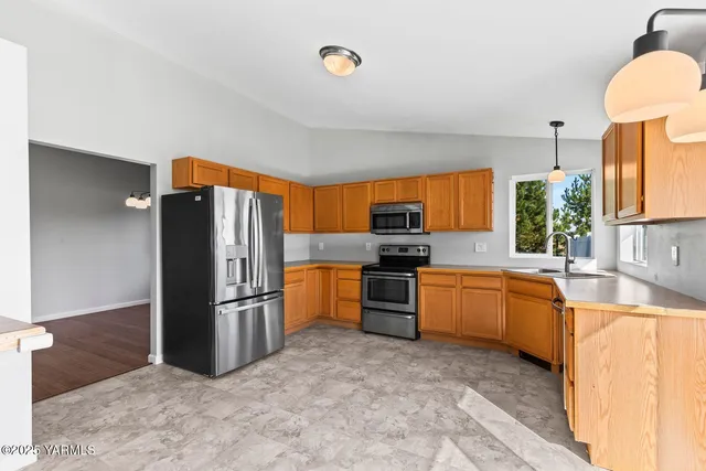 a kitchen with stainless steel appliances granite countertop a refrigerator and a sink