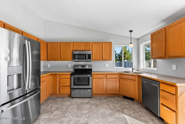 a kitchen with stainless steel appliances granite countertop a refrigerator sink and stove