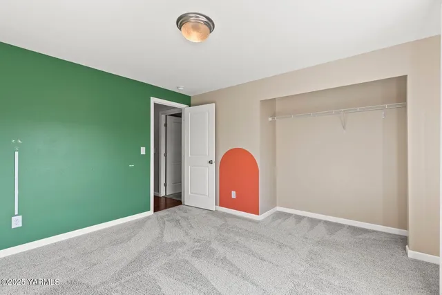 an empty room with a fireplace and entryway