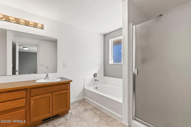 a bathroom with a tub sink and mirror