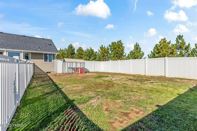 a view of an house with backyard and tree