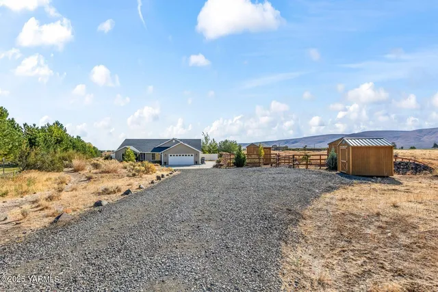 a view of a dry yard with wooden fence