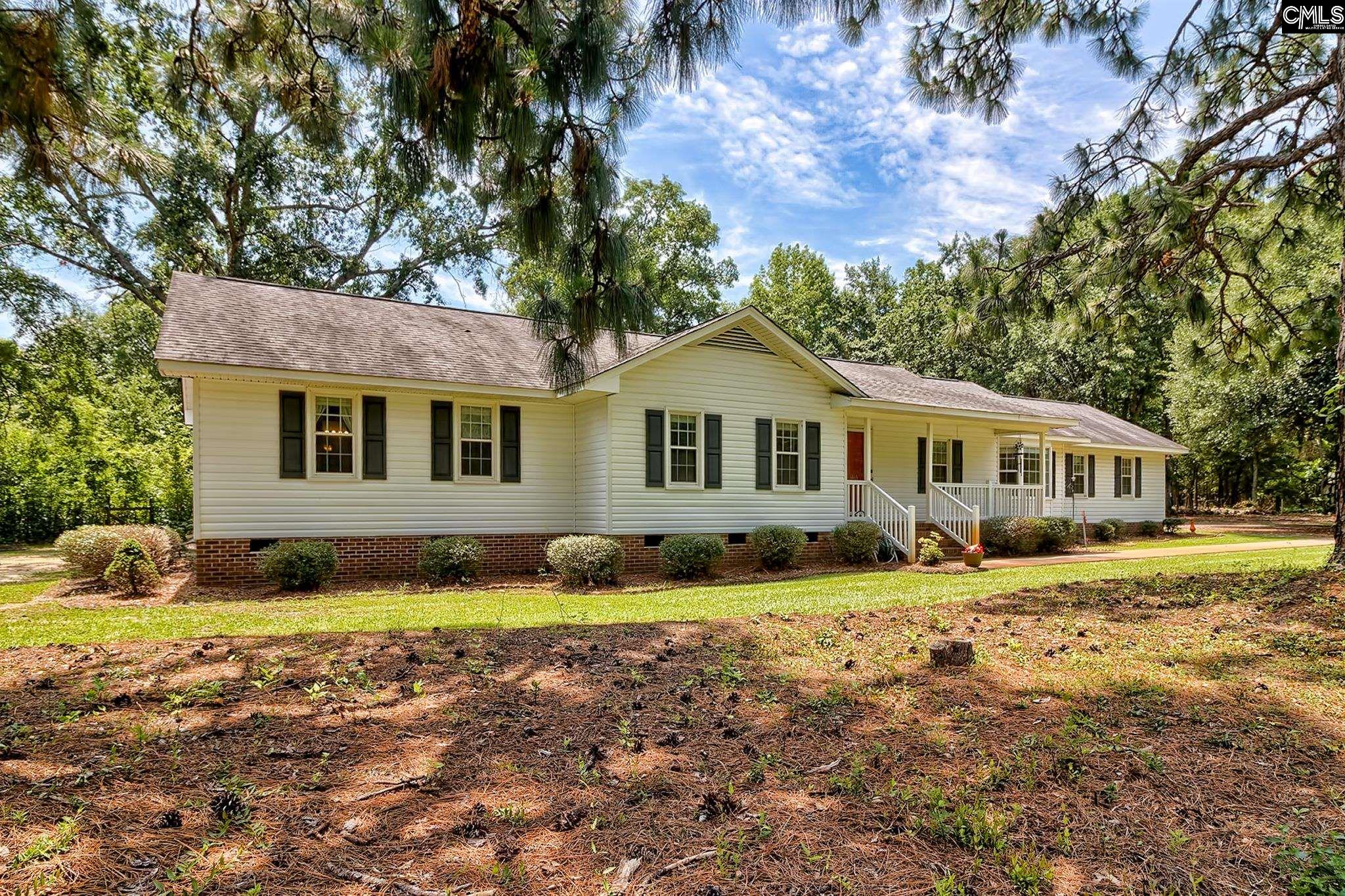 1415 State Rd S-28-55 Lugoff, SC 29078 - Photo 3 of 39 a front view of a house with a yard