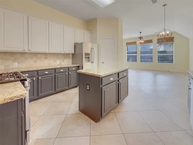 a kitchen with stainless steel appliances granite countertop a stove a sink and a refrigerator