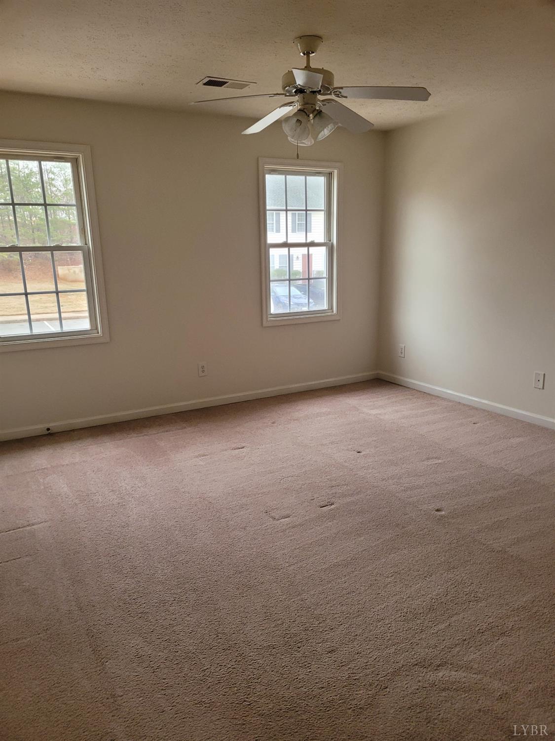 716 Leesville Road, Unit 603 Lynchburg, VA 24502 - Photo 4 of 13 an empty room with windows and chandelier fan