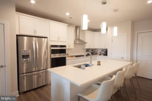 a kitchen with stainless steel appliances a refrigerator a sink a stove a microwave and island