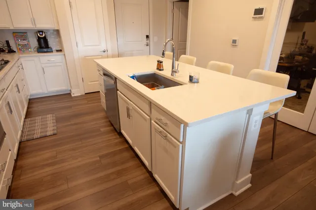 a kitchen with a sink and wooden floor