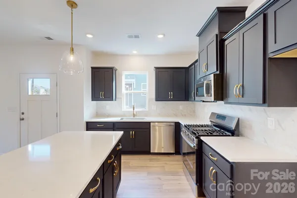 a kitchen with stainless steel appliances granite countertop a sink stove and refrigerator