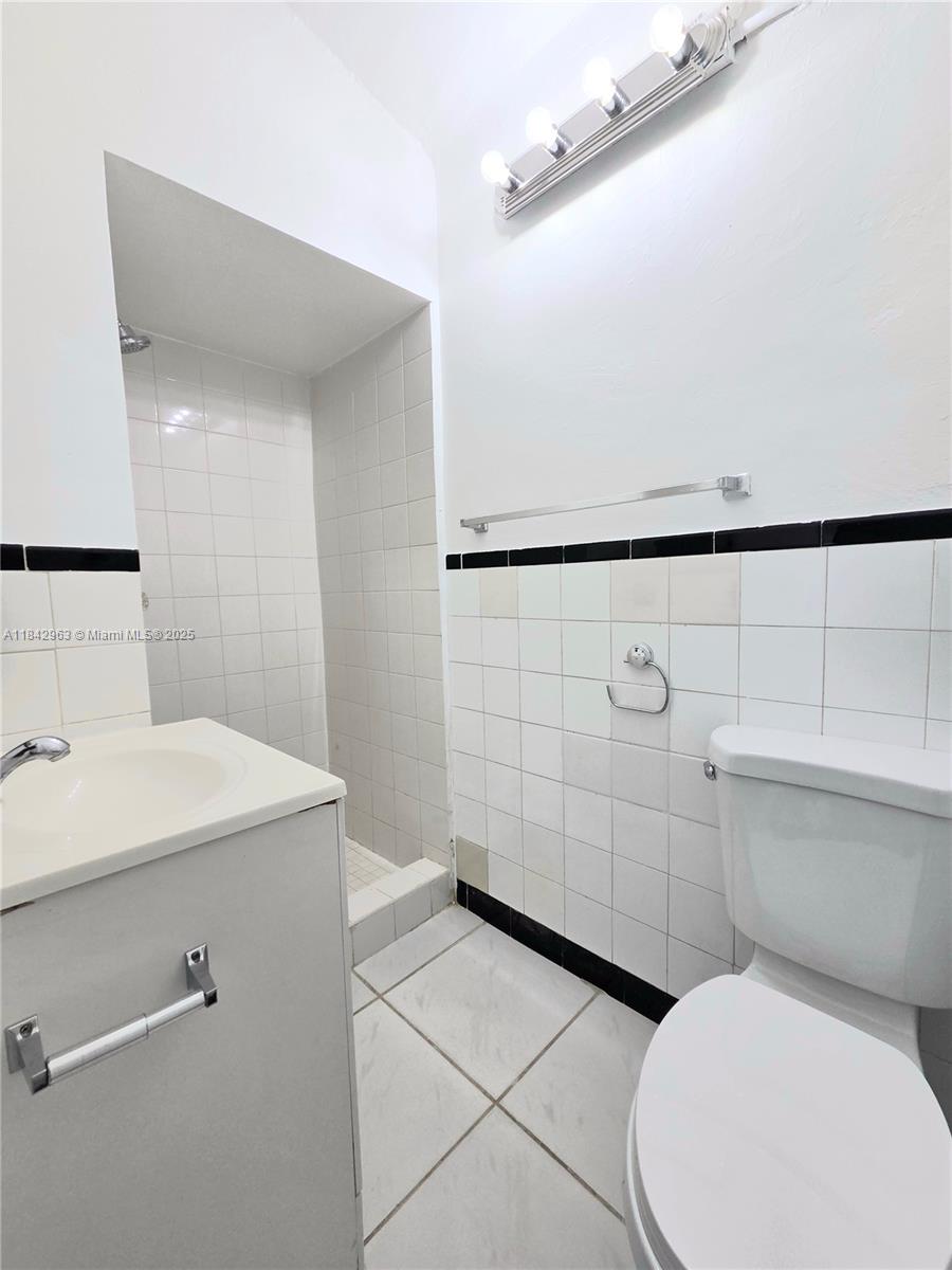 Allapattah Miami, FL 33142 - Photo 8 of 9 a bathroom with a toilet a sink and mirror