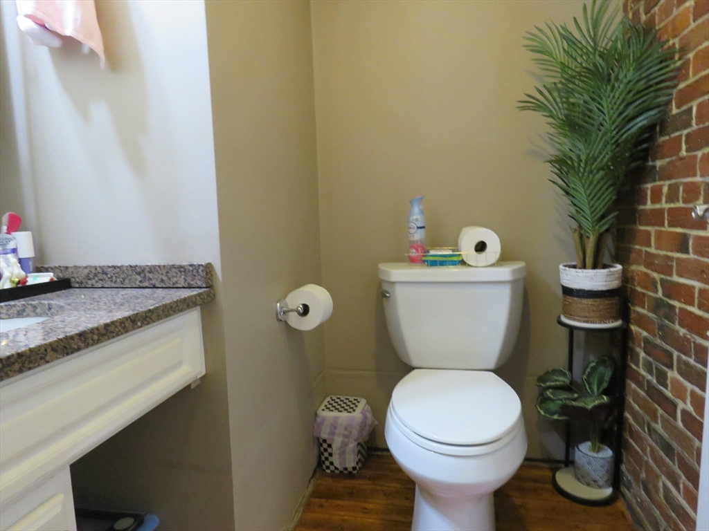 61 Market Street, Unit 2B Lowell, MA 01852 - Photo 14 of 20 a bathroom with a granite countertop toilet and a sink